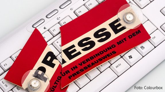 Auf einer Computertastatur liegt ein in Zwei geteiltes Schild mit der Aufschrift Presse