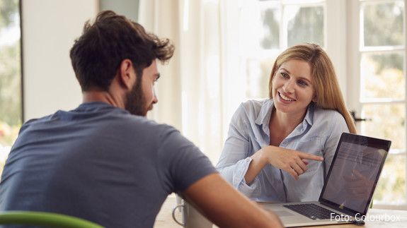 couple, at home, laptop, computer, online, working from home, connected, the internet, tech, shopping, buying, choosing, holiday, finance, personal finance, checking, investments, savings, pension, retirement, man, men, male, woman, women, female, two people, people, person, together, caucasian, 20s, twenties, 30s, thirties, horizontal, front view, waist up, happy, smiling, laughing, sitting, table